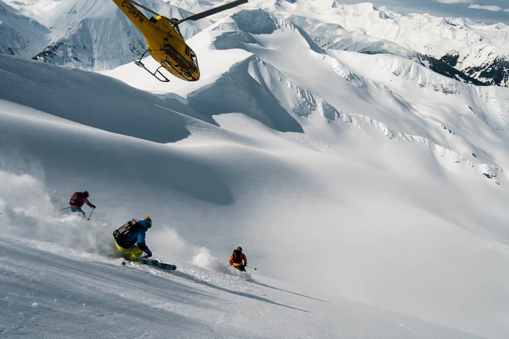 Heli-skiers get buzed by helicopter overhead